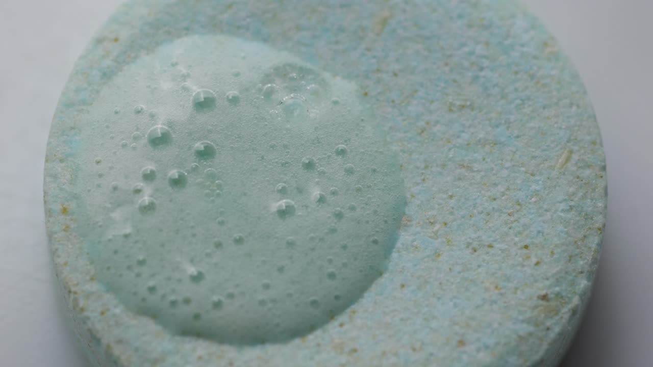 Close-up of a bubbling chemical reaction in a glass of water