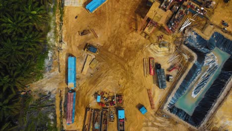 Cinematic-Drone-Footage-of-Onshore-Drilling-Rig-equipment-structure-for-oil-exploration-and-exploitation-in-the-middle-of-jungle-surrounded-by-palm-oil-trees-during-sunset-and-high-oil-price