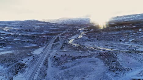 Una-Carretera-Que-Atraviesa-El-Paisaje-Cubierto-De-Hielo-De-La-Isla-Fantasma-De-Islandia---Antena