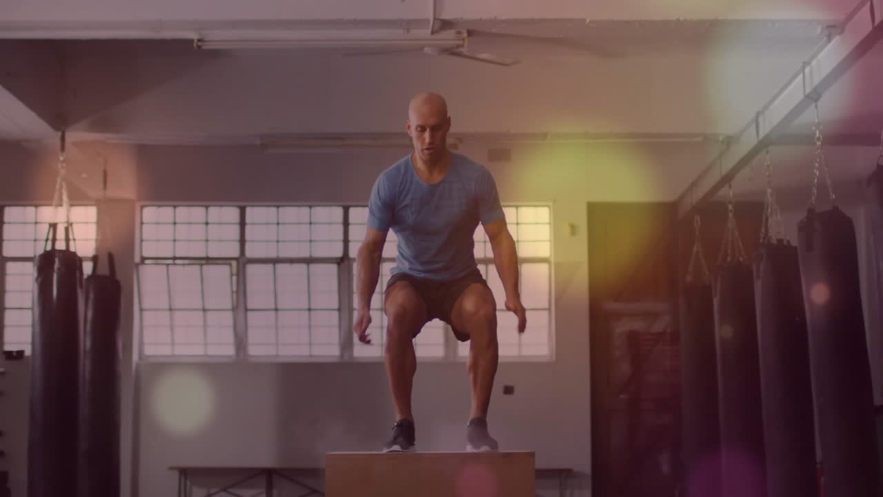saltando a la caja, el hombre haciendo ejercicio en el gimnasio con animación de luz colorida