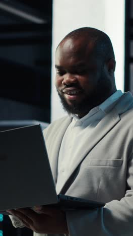 Vertical video Data center admin coding, writing script on laptop, identifying bottlenecks