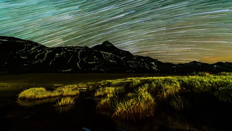 Star-trails-across-night-sky-in-nature-landscape-time-lapse-with-mountains-|-Alps,-Italy---Valmalenco