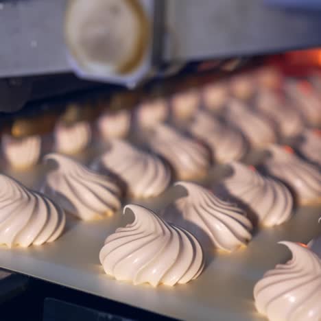 marshmallow depositing machine making zephyr at confectionery factory. moving marshmallows along a conveyor line. marshmallow zephyr production process closeup