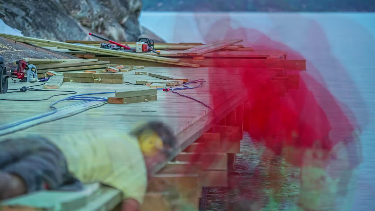 낮에 호숫가를 따라 저속으로 목조 부두를 건설하는 노동자들의 클로즈업 샷