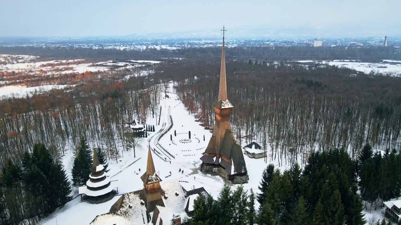 Vue aérienne par drone du monastère Peri-Sapanta en hiver, Roumanie. Église principale et bâtiment, visiteurs, forêt dénudée et neige autour.