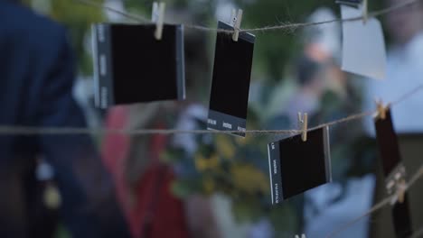 fotos polaroid colgadas a través de hilo en una hermosa recepción de boda de verano