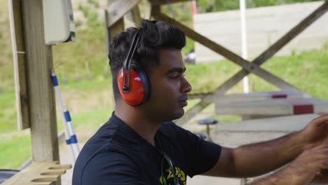 Male-Shooter-Puts-On-Ear-Muffs-At-The-Firing-Range