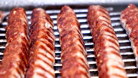 closeup slowmo de kebabche de salchichas en una parrilla de barbacoa en una cocina