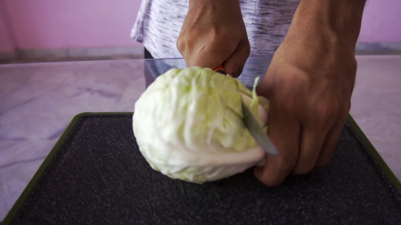 joven cortando repollo para ensalada