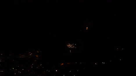 Celebración-Con-Muchos-Pequeños-Y-Coloridos-Fuegos-Artificiales,-Sobre-Un-Pueblo-De-Montaña,-Por-La-Noche