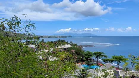 aerial view of papeete coastline, ocean with coral reefs, and tropical island of moorea in the far distance in french polynesia, south pacific