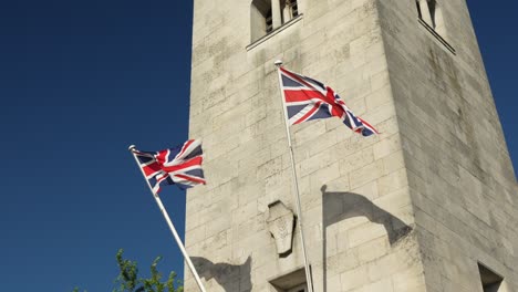 war memorial tower with british flags, in 4k, slow motion