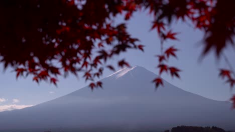 el monte fuji en la distancia con la hoja de arce japonesa enmarcándola en un día claro y soleado