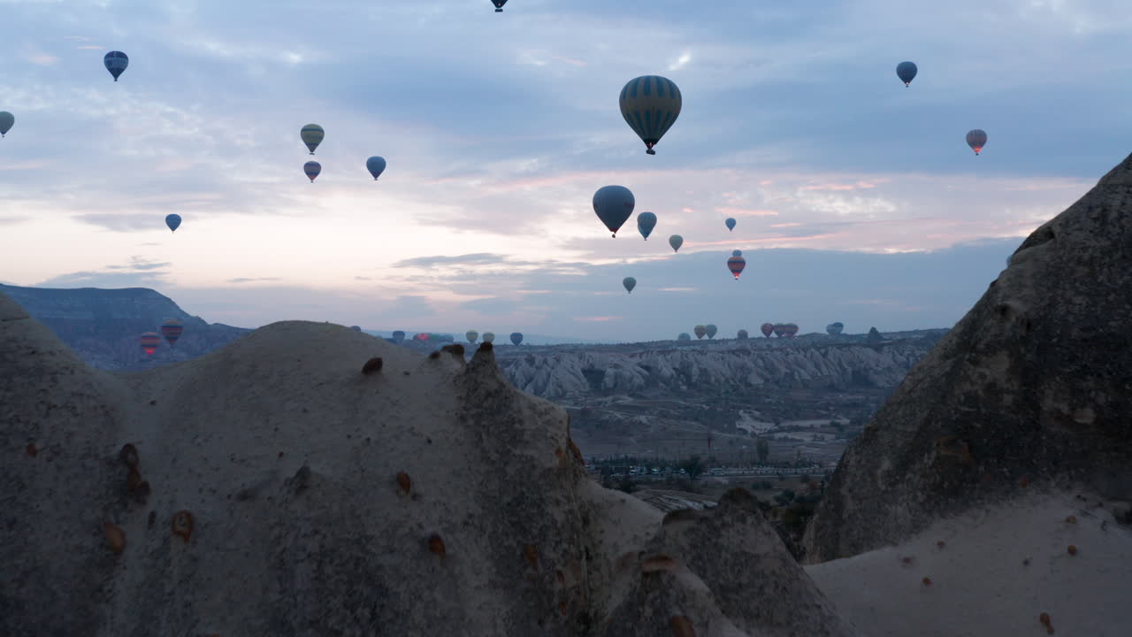 globos aerostáticos volando en el cielo del amanecer en capadocia, turquía - toma aérea de drones