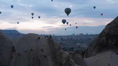 hot air balloons flying in sunrise sky in cappadocia, turkey - aerial drone shot