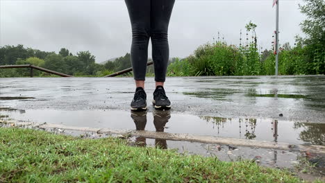 Jumping-in-water-puddle,-continuous-close-up,-low-angle-shot