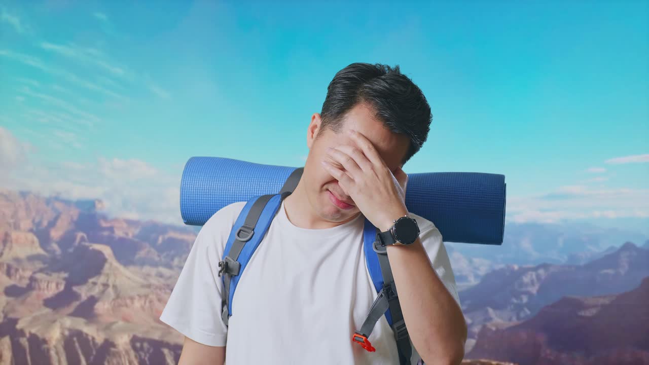 Close Up Of Asian Male Hiker With Mountaineering Backpack Having A Headache While Traveling At The Top Of Mountain