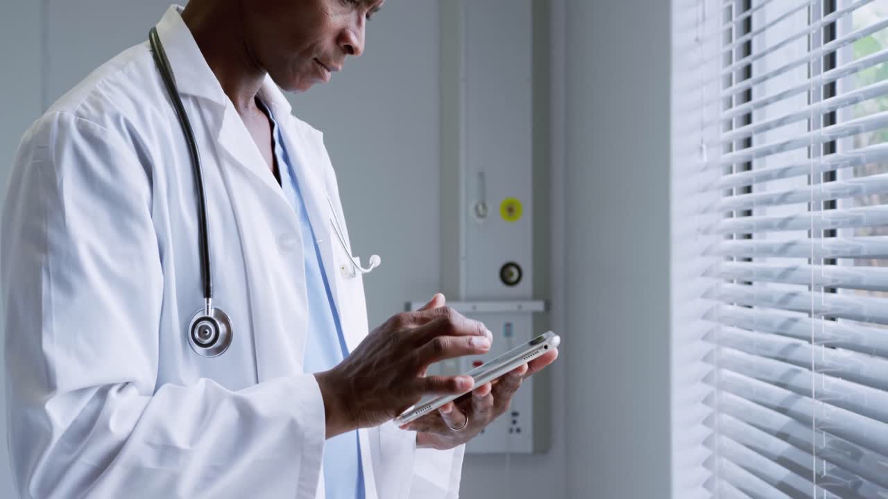 Side view of African American male doctor using digital tablet in hospital 4k