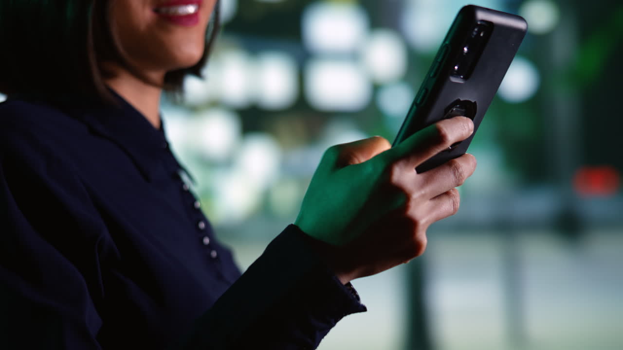 아시아 여성이 걸어서 메시지를 읽습니다.