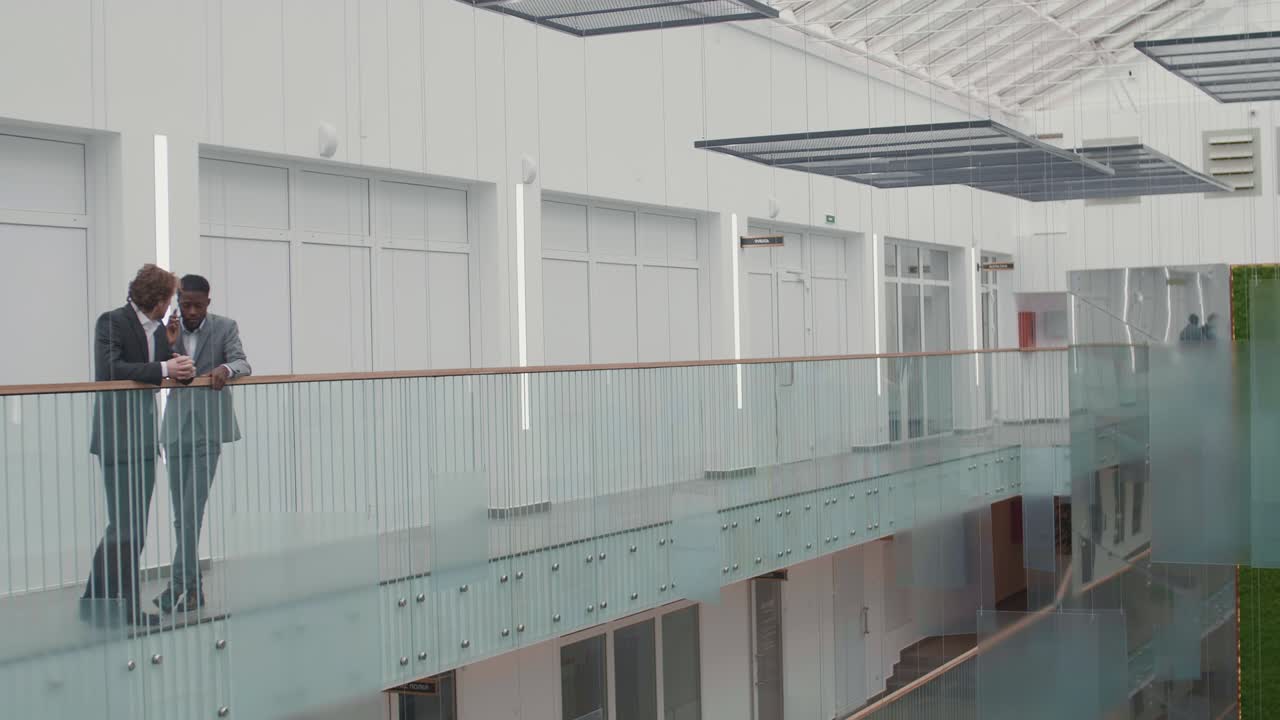 dos hombres de negocios hablando en el pasillo