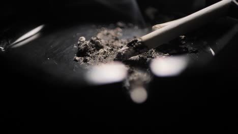 close up smoking cigarette on man hand.black ashtray. scene c