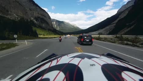 rear facing pov clip of a motorcycle rider on a twisty mountain forest road in the summer