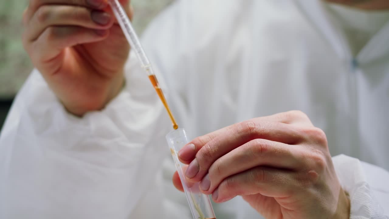 Scientist Pipetting Liquid into Test Tube with Blood Sample in Laboratory
