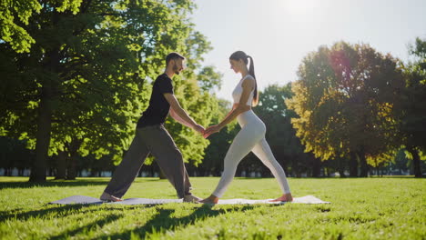 couple practicing partner yoga in a park