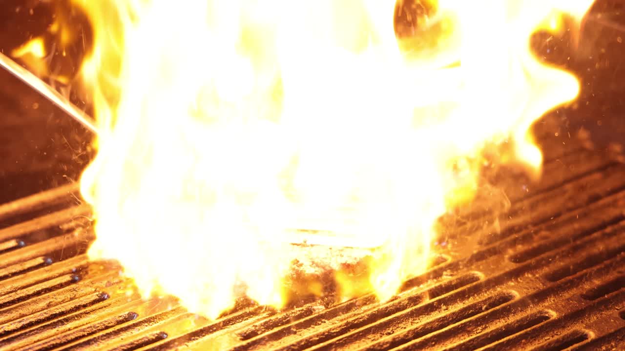 버거 패티는 그릴에서 불꽃에 싸여 있습니다.