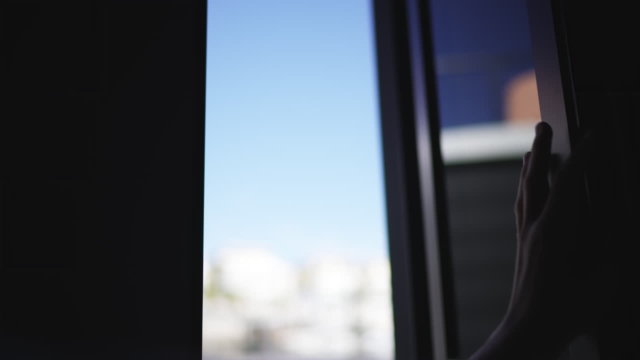Silhouette of Hand Opening and Closing Window Blind