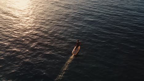 aerial overhead view of male using electric surfboard across in sea at punta galera, ibiza