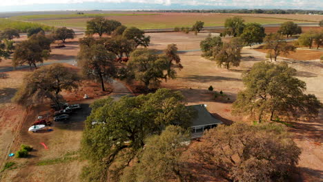 Aerial-Drone-shot-of-a-Rural-Farm-home-panning-through-the-oak-trees