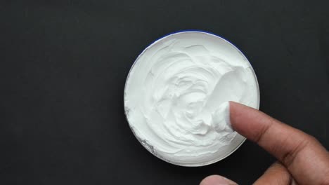 man applying beauty cream onto skin