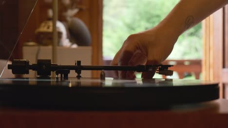 low angle view of a vintage turntable being turned on and spinning by a person, slow motion 4k