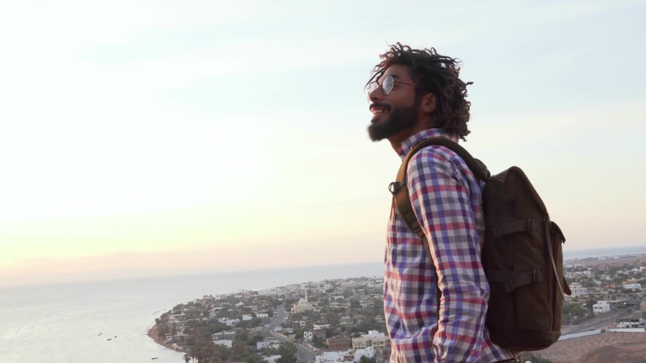 hombre adulto de oriente medio mirando el horizonte de pie en un acantilado al amanecer