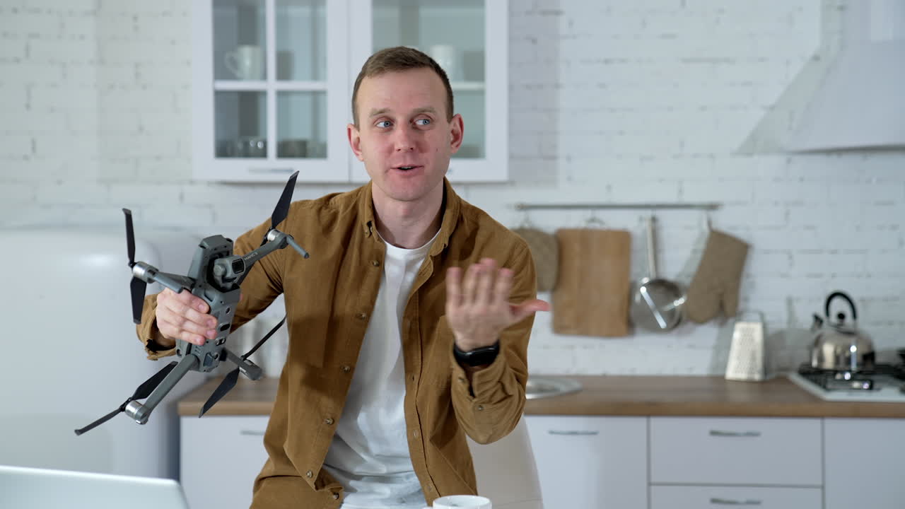 Man at home with drone. Young man playing with drone at home