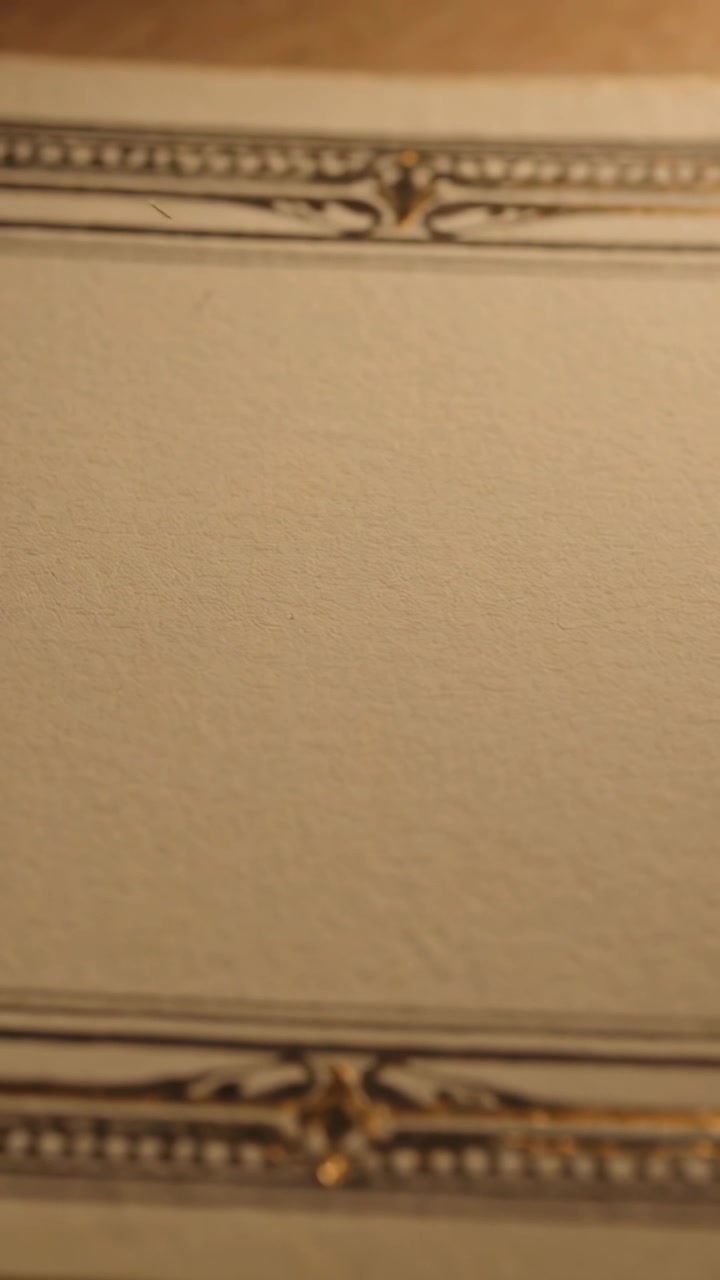 Video verticale: All'avvio della registrazione, la telecamera inquadra una parete beige con finiture dorate ornate nella stanza, mostrando cambi di messa a fuoco.