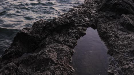 Top-view-of-a-rock-over-shore-beach-in-Alghero,-Sardinia-island-in-Italy