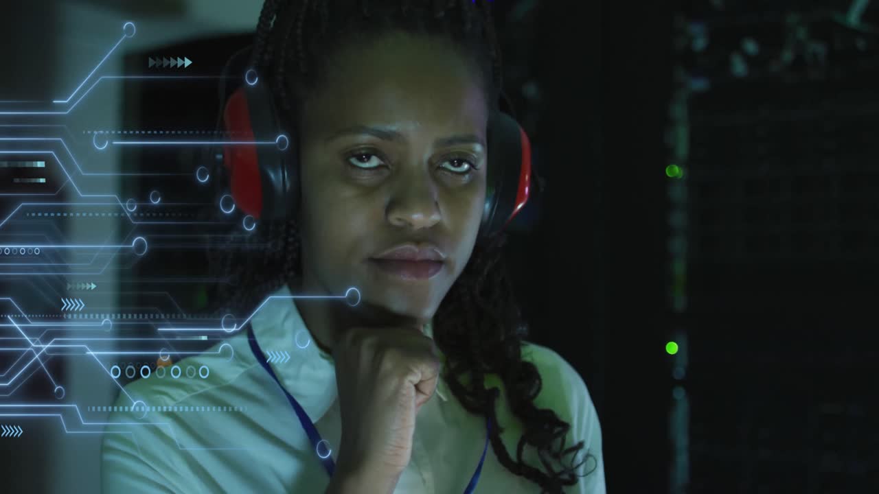 Animation of integrated circuit over african american woman working on laptop in server room