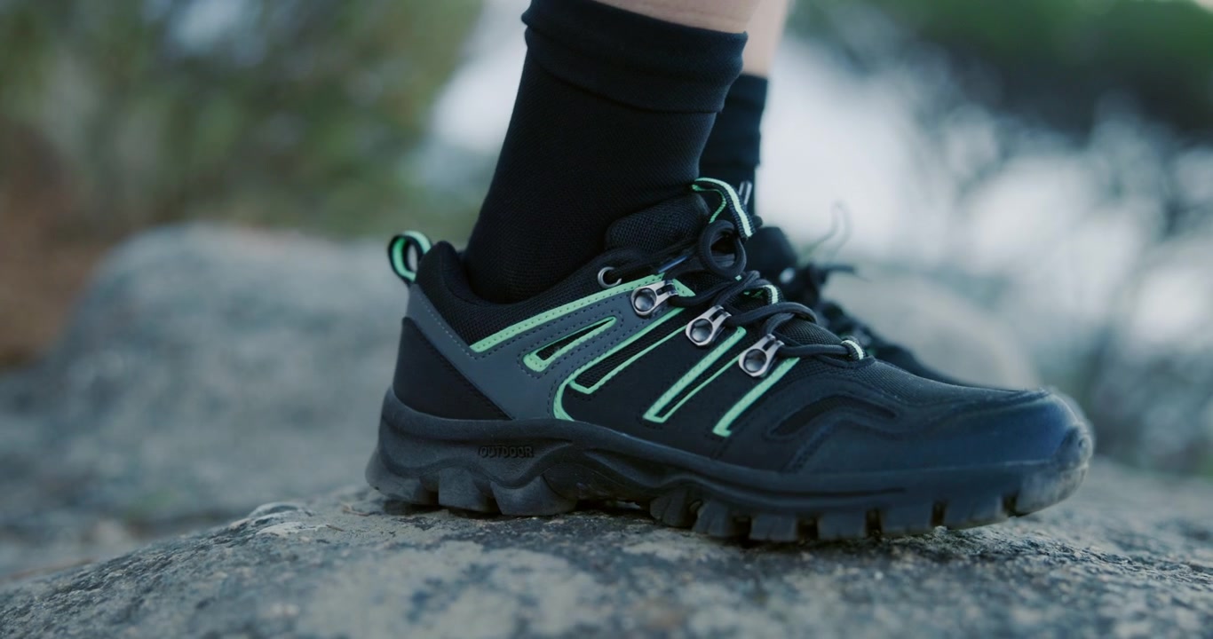 Escursionista che allaccia le stringhe delle scarpe da trekking prima di camminare sulle rocce