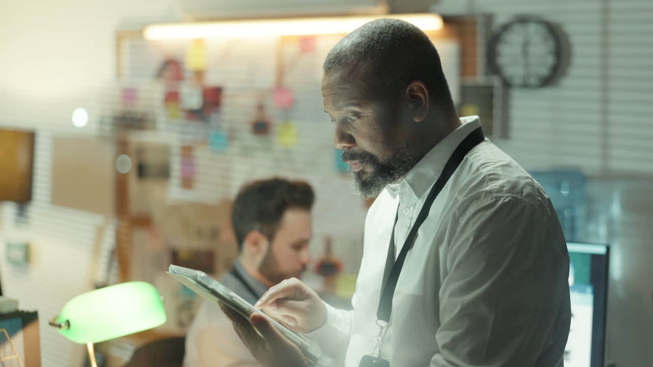 Detective in Office Investigating Case on Tablet