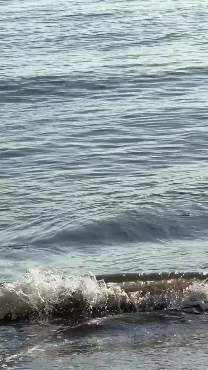 Onde oceaniche calme che si infrangono dolcemente sulla riva.