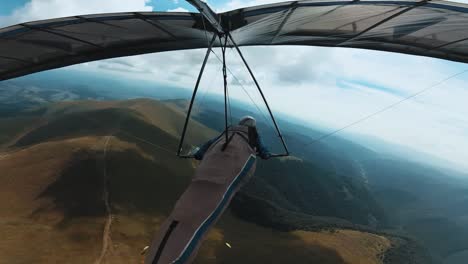 hang glider circles under the clouds