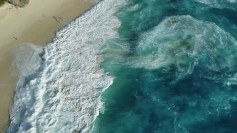 Atemberaubender-Sonnenuntergang-Am-Strand-Von-Kelingking:-4K-Drohnenvideo-Aus-Der-Luft,-Das-Gefährliche-Klippen,-Türkisfarbene-Wellen-Und-Einen-Einsamen-Strand-Auf-Bali,-Nusa-Penida,-Zeigt