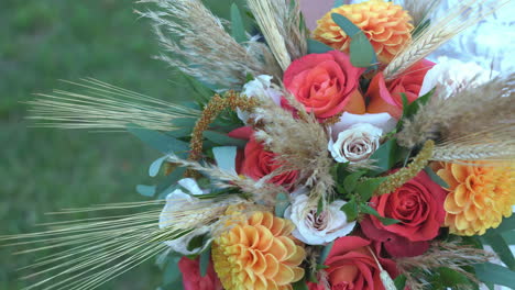 shot of flower bouquet on a wedding day, with woman holding the flowers