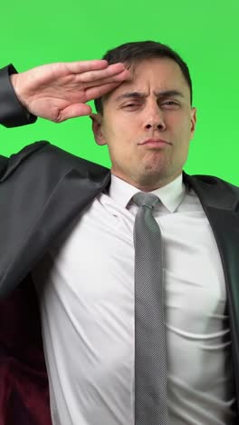 man in suit saluting and smiling on green screen