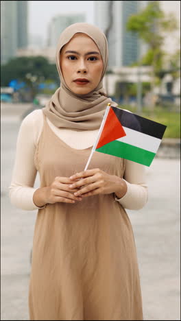 woman in hijab holding palestine flag
