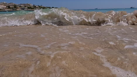 subiendo de cerca de una hermosa playa con agua de mar azul mientras las olas se rompen hacia la cámara durante un maravilloso viaje turístico de verano en un día sin nubes en cámara lenta