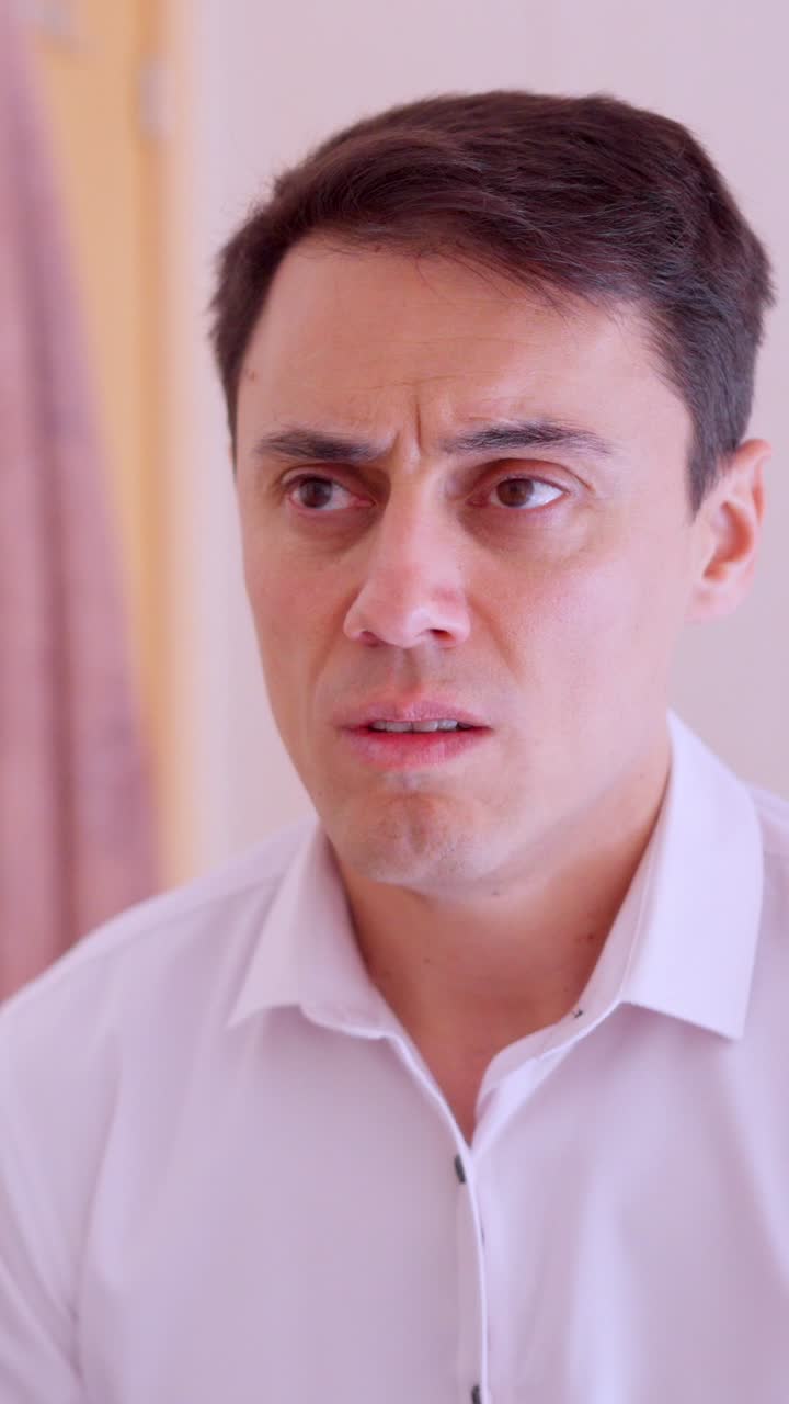 Sad businessman looking at mirror while getting dressed in bathroom