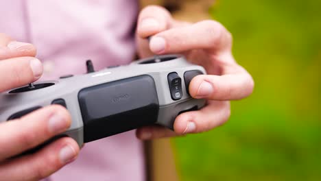 person use joysticks on wireless remote control to fly drone, czechia